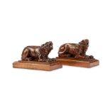 A pair of carved walnut recumbent lions, mid 19th century