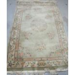 A modern Chinese wool rug with pale green ground decorated with flowers,155cm x 245cm