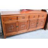 A 20th century Chinese rosewood sideboard with four drawers above corresponding cupboard doors