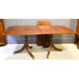 A mahogany twin pedestal dining table, with extra leaf, with brass caps and castors, 182 long,