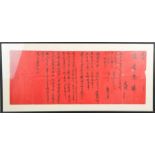 A Chinese presentation scroll, black script on red ground, 25 by 66cm.