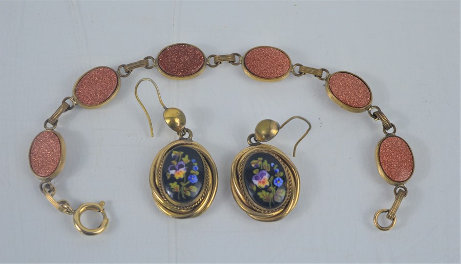 A bracelet and pair of drop earrings, painted with flowers.