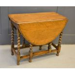 A reproduction oak drop-leaf table with barley twist legs, 73cm by 90cm by 41cm (leafs down)