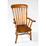 A Victorian kitchen armchair, with slatted back, moulded seats and raised on turned legs united by