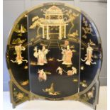 A large Chinese black lacquered tri-fold screen, depicting a Temple composed of carved soapstone,