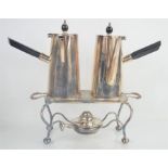 A pair of chocolate pots with ebonised handles together with a warming plate and burner by Asprey of