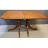 A Regency mahogany twin pedestal dining table, with an extra leaf, 104cm by 74cm by 149cm without