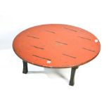 An antique Chinese table painted red and on raised four splayed legs, 24cm by 66cm