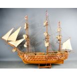 A vintage wooden hand made battle ship, flying British and English flags, complete with sails,