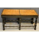 An antique long stool with cane work seat, and turned legs, 45 by 91 by 40cm.