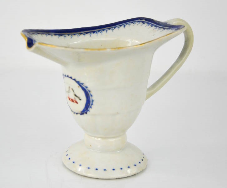 A 19th century sauce boat, bearing armorial crest with two birds, footed base, 11cm high.