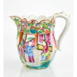A Chinese Famille Rose jug, painted with figures in a garden, the scalloped and embossed rim painted