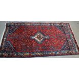 A 20th century Assadabad Persian tribal rug with red ground, 210cm by 110cm