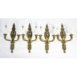 A set of four Empire style brass wall lights, each with twin branches, and the backs cast with