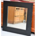 A modern black painted line moulded mirror with bevelled plate, 92cm by 92cm