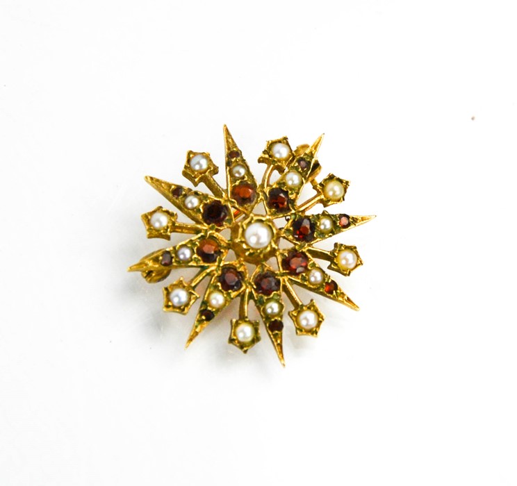 A gold (tested as), seed pearl and garnet starburst brooch, 4.6g.