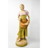 A Royal Dux figure of a woman carrying wheat, 54cm high.