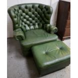 A green leather Chesterfield type button back wing armchair with matching footstool.