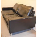 A black leather modern two seater settee raised on chrome feet, 94cm by 182cm by 100cm.