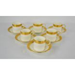 A set of six Royal Worcester coffee cans and saucers in white with decorative gilding to the rims.