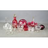 A group of cut glass decanters, cranberry glassware and other examples.