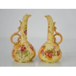 A pair of Royal Worcester blush ivory ewers, painted with flowers, 15cm high.