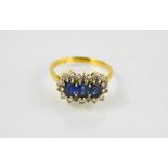 An 18ct gold and sapphire ring, the three oval cut sapphires, bordered with nineteen diamonds,