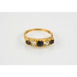 A gold, diamond and sapphire ring, the three sapphires interspersed with two diamonds.