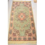 A fine Turkish Kayseria rug with green ground, 5ft11 by 2ft11ins.
