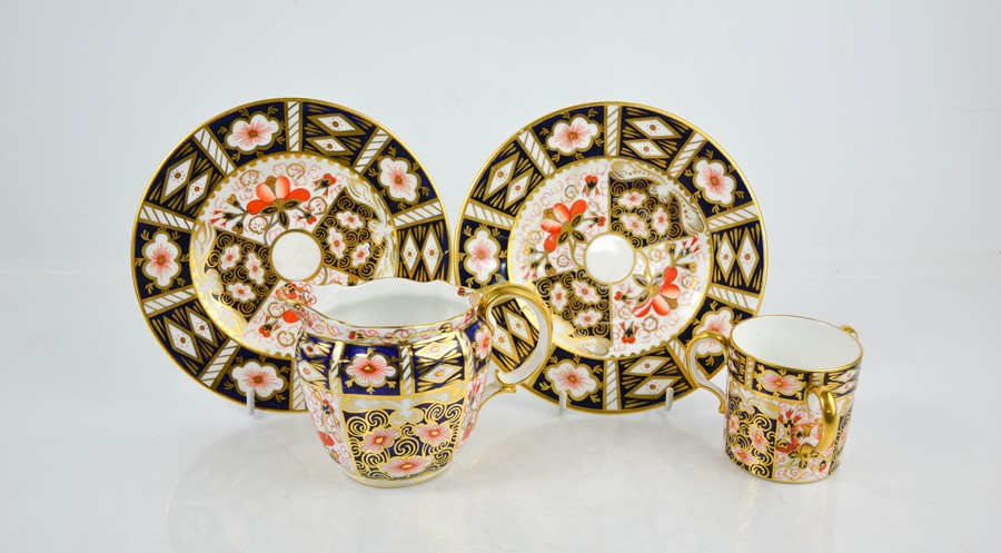 A Royal Crown Derby loving cup, pair of plates, and milk jug. (4)