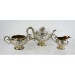A fine George III three pieces silver tea set, embossed with flowers and cartouche, comprising