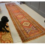 An antique runner, with deep red ground and diamond motifs, late 19th/early 20th century 460 by