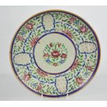 An early 19th century stoneware glazed dish, painted with flowers, 27cm.