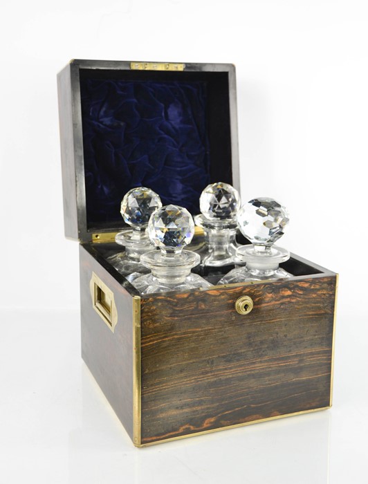 A 19th century coromandel decanter box, brass bound, with two handles enclosing four cut glass
