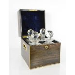 A 19th century coromandel decanter box, brass bound, with two handles enclosing four cut glass