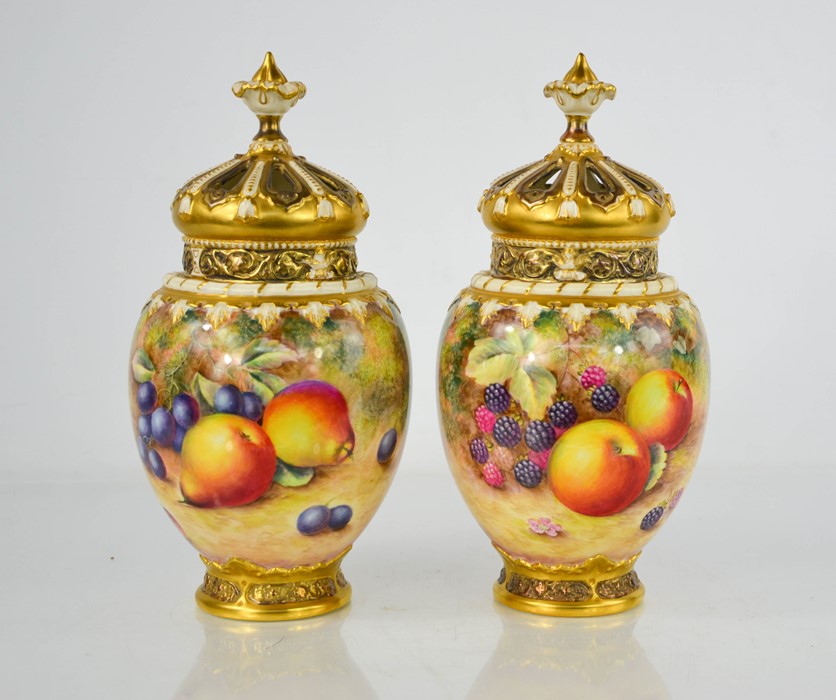 A fine pair of Royal Worcester pot pourri vases with inner and outer covers, painted with fruit on