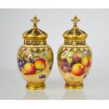 A fine pair of Royal Worcester pot pourri vases with inner and outer covers, painted with fruit on