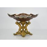 A 19th century gilt metal and porcelain tazza, the dish decorated with exotic birds and foliage, the