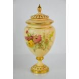 A Royal Worcester blush ivory vase and cover, painted with flowers and gilded highlights, 28cm high.