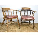 A pair of 19th century captains chairs with red leather cushions.