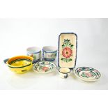 A group of French Quimper pottery: a pair of oil dishes, a porringer with yellow ground, an egg cup,