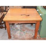 An oak dining table with central removable leaf and winding handle