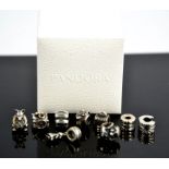 A group of nine Pandora silver charms, in a Pandora box.