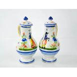A pair of French Quimper oil and vinegar bottles with covers.
