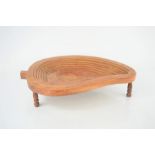 A treen bowl on raised on three turned feet