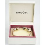 A Pandora bracelet with six silver charms and original presentation box.