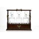 A fine 20th century mahogany tantalus, with three cut glass decanters, with faceted ball stoppers,