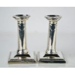 A pair of candlesticks, with sconces, step bases and beaded decoration with ribbon and bows, by
