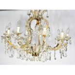 An antique French cut glass chandelier, with eight branches clad in glass panels.