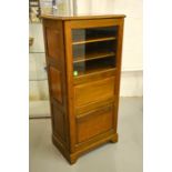 A mahogany music cabinet with glazed upper panel.